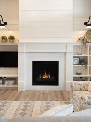 beautiful white fireplace surround with entertainment center and custom shelving